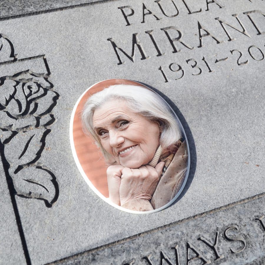 A ceramic memorial photo of a woman set into a headstone